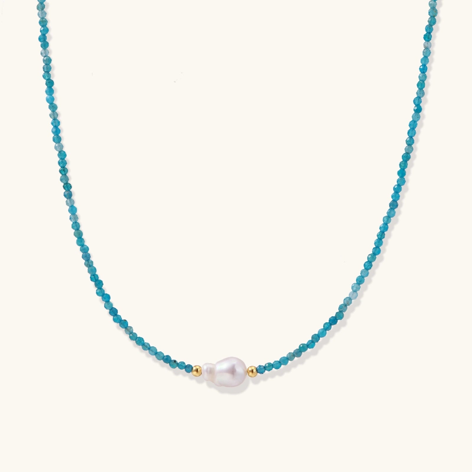 Dainty teal apatite beaded necklace with a single freshwater pearl centerpiece flanked by two small gold beads, adjustable gold clasp.