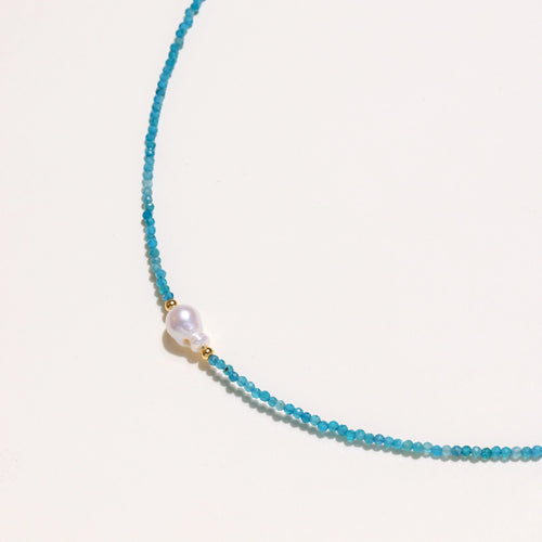 Dainty teal apatite beaded necklace with a single freshwater pearl centerpiece flanked by two small gold beads, adjustable gold clasp.